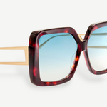 Close-up of the Macy Sunglasses featuring oversized square tortoiseshell acetate frames, gold metal arms, and aqua gradient lenses against a white background.