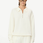 Model wearing a KABE SHOP INC cream oversized French terry half-zip polo sweatshirt with a collar and zip closure.
