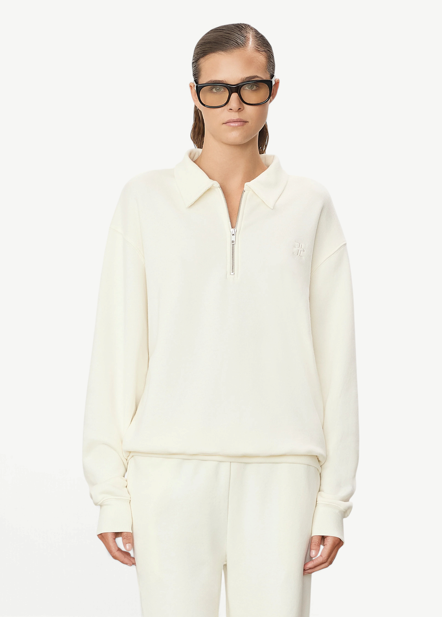 Model wearing a KABE SHOP INC cream oversized French terry half-zip polo sweatshirt with a collar and zip closure.