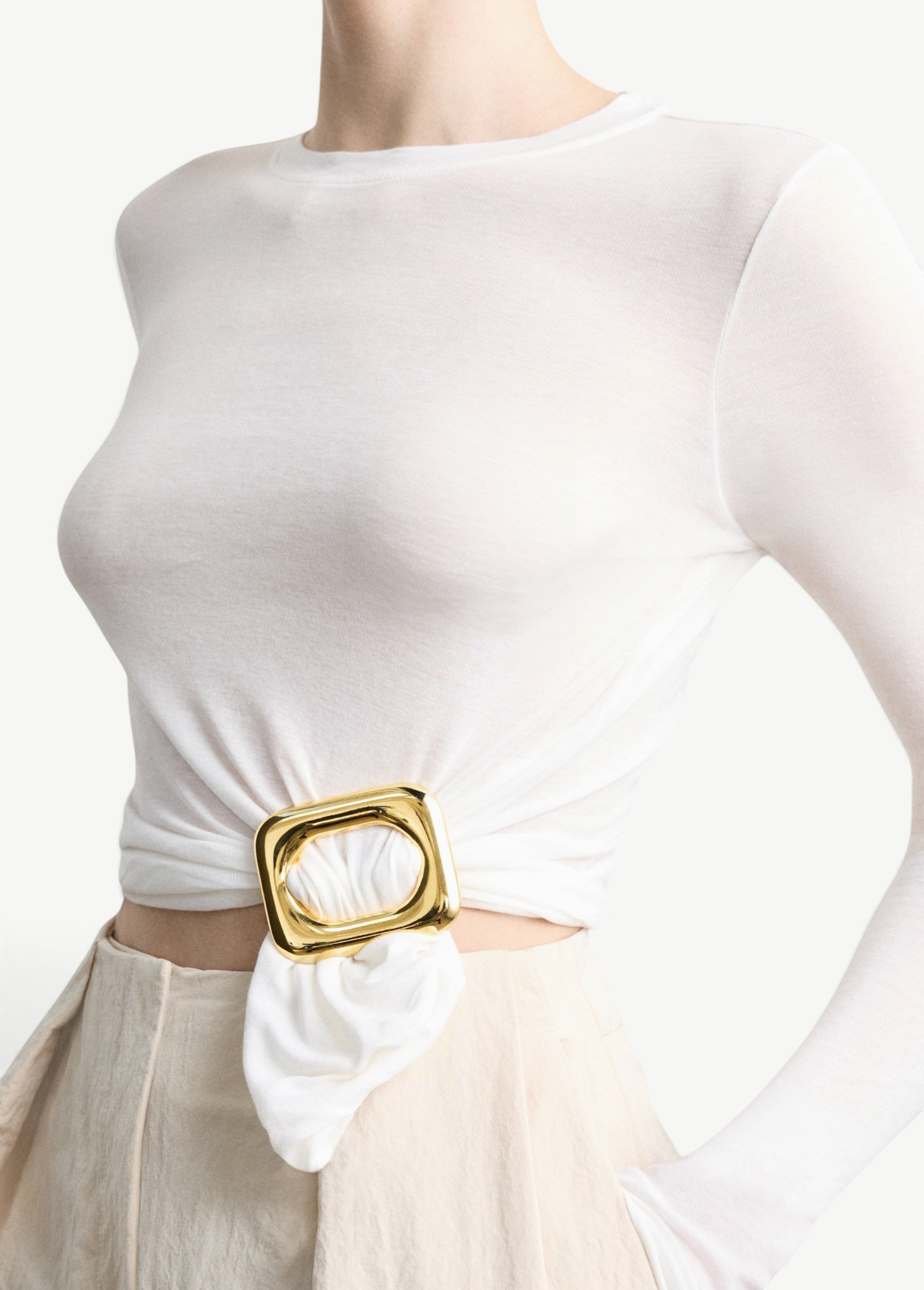 KABE SHOP INC Sculpted Slide featuring a polished gold square ring cinching a white long-sleeve top at the waist.