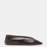 A single Luna Slipper Shoe in dark brown, crafted from supple plum lambskin with minimalist seamless leather detailing and a slightly pointed toe, is displayed in side profile against a plain white background.