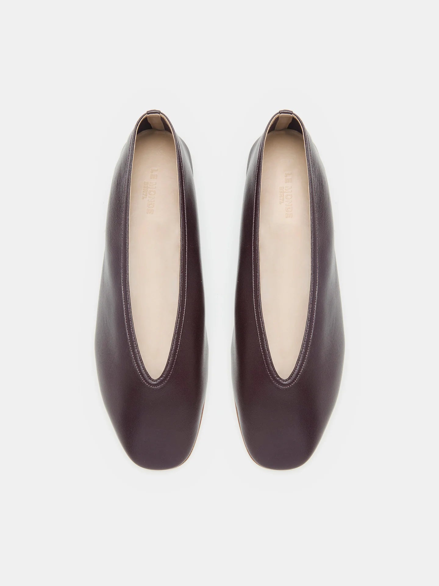 A pair of Luna Slipper Shoes in dark brown leather, featuring slip-on styling with almond-shaped openings, slightly square toes, and subtle leather detailing, displayed from above on a white background.