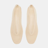 A pair of beige, minimalist Luna Slipper Shoes made from patent leather with an elongated oval opening is displayed on a white background, viewed from above.