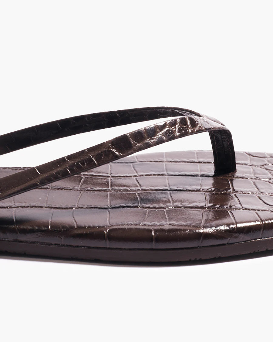 Close-up of the Square Toe Lily sandal in dark brown, featuring a square toe and textured, crocodile-embossed leather on the footbed and straps, displayed against a plain white background.