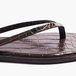 Close-up of the Square Toe Lily sandal in dark brown, featuring a square toe and textured, crocodile-embossed leather on the footbed and straps, displayed against a plain white background.