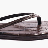 Close-up of the Square Toe Lily sandal in dark brown, featuring a square toe and textured, crocodile-embossed leather on the footbed and straps, displayed against a plain white background.
