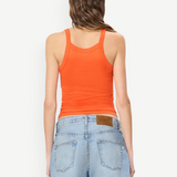 Back view of a person wearing a bright orange slim fit Duke Tank and light wash denim shorts.