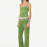A person wearing a green tank top layered over a white tank top, paired with green wide-leg Low Rise Lounge Pant and tan slip-on shoes.