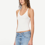 Model wearing a white KABE SHOP INC ribbed V-neck racerback tank top with a slim fit, paired with denim shorts.