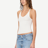 Model wearing a white KABE SHOP INC ribbed V-neck racerback tank top with a slim fit, paired with denim shorts.