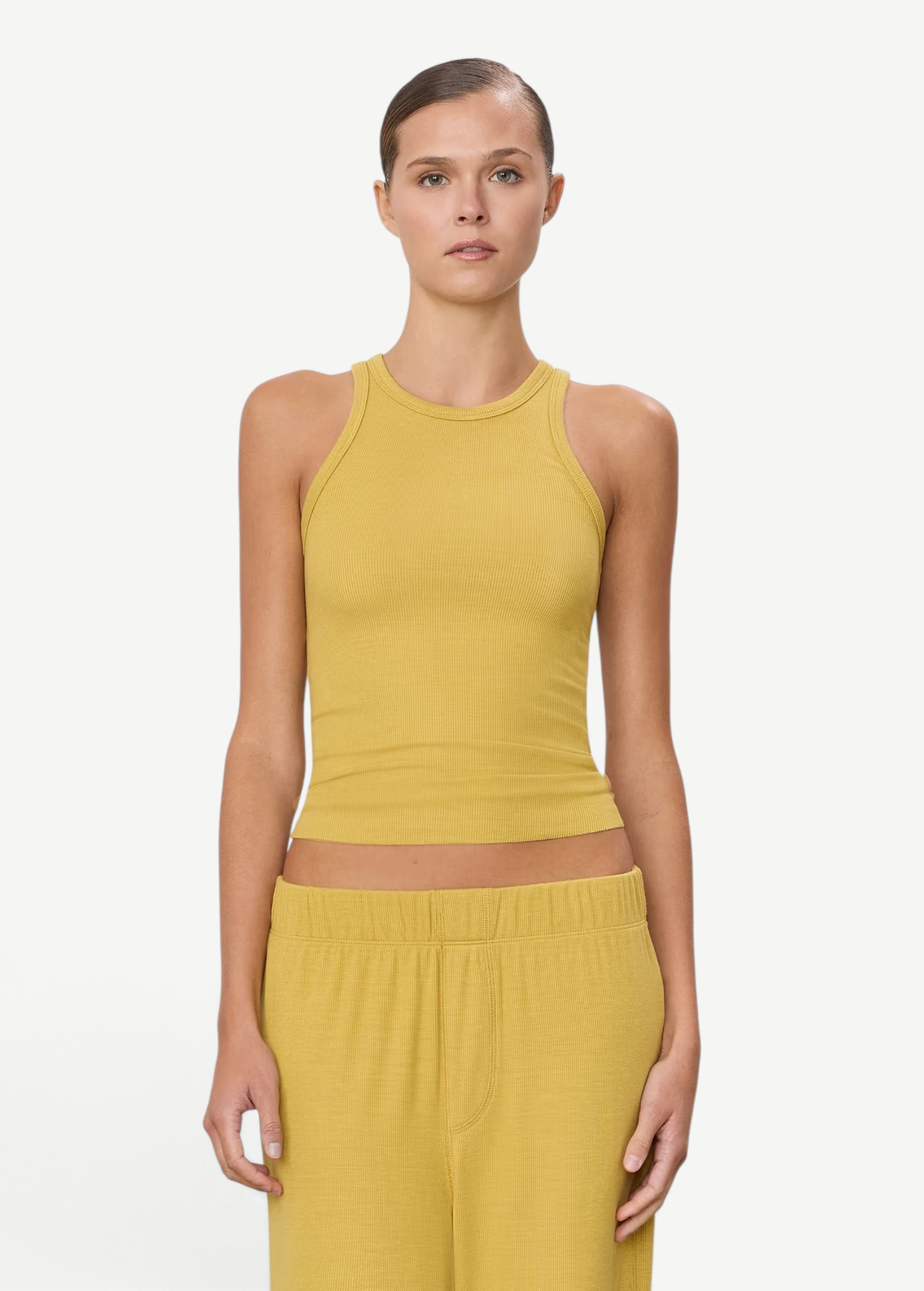 Model wearing a mustard yellow KABE SHOP INC high neck fitted ribbed tank top with a slim silhouette