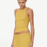 Model wearing a mustard yellow KABE SHOP INC high neck fitted ribbed tank top with a slim silhouette