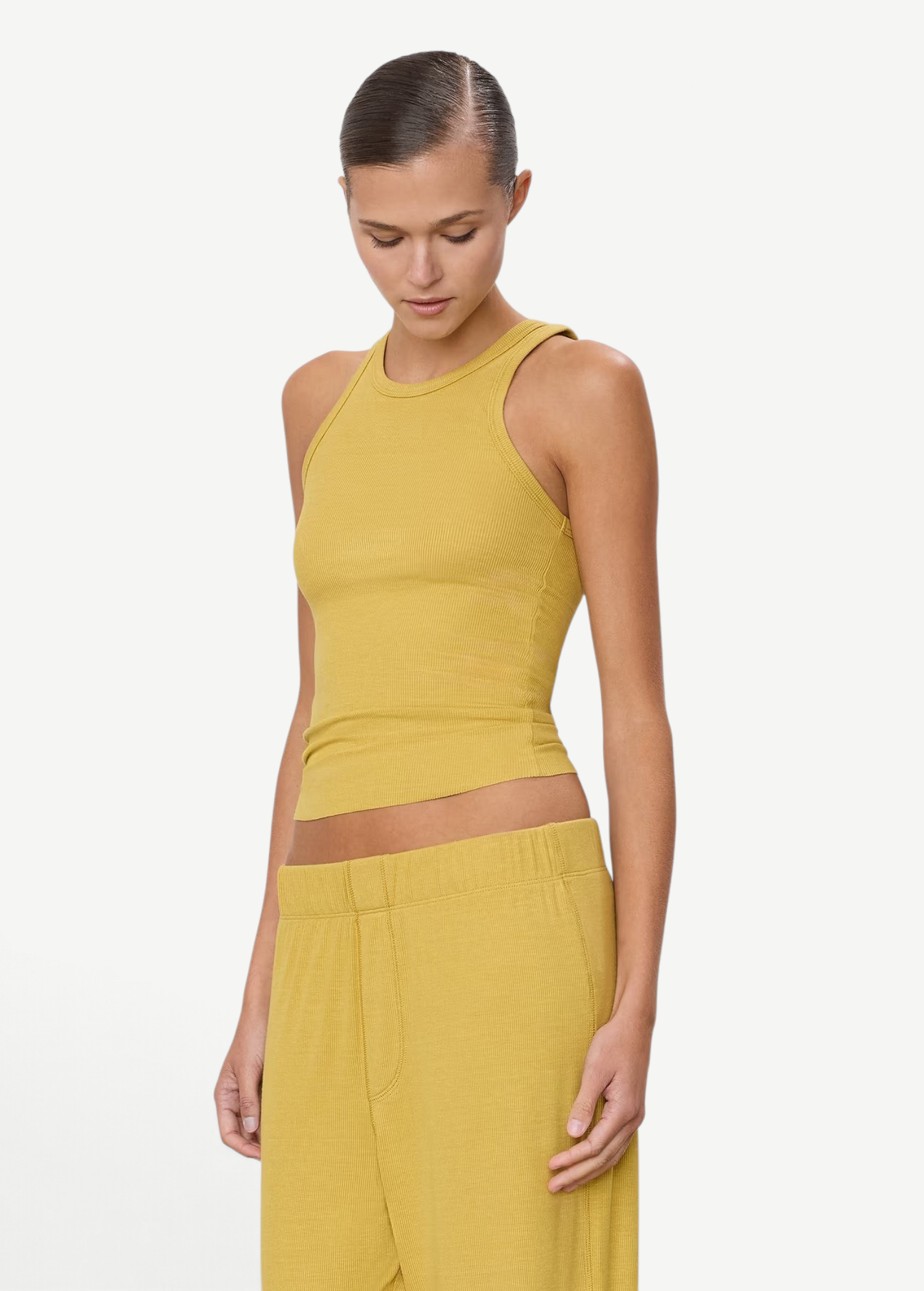 Model wearing a mustard yellow KABE SHOP INC high neck fitted ribbed tank top with a slim silhouette