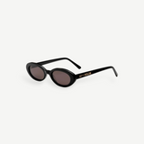 Certainly! Here’s a rewritten version using your product data: The Sylvie sunglasses feature black, oval-shaped frames with dark lenses and bold, thick sides adorned with LU—GOLDIE in gold lettering on the left arm, all showcased against a crisp white background—a true pocket rocket accessory that complements any vintage suit.