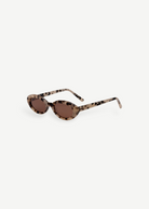 Beige and black tortoiseshell oval Sylvie sunglasses featuring brown UV400 lenses, displayed at an angle on a white background.
