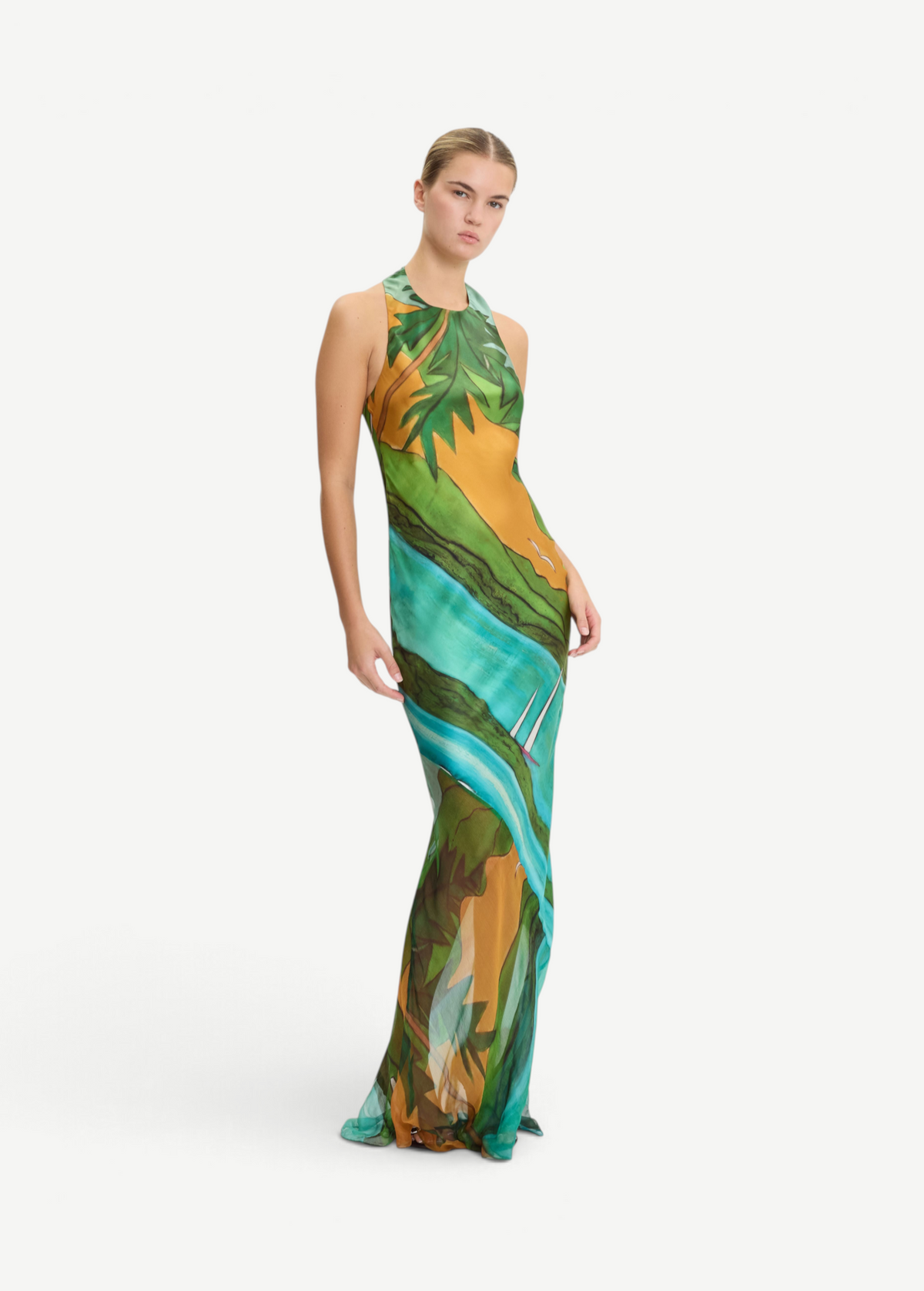 Model wearing a KABE SHOP INC Magdalena long silk maxi dress with a halter neckline and landscape print
