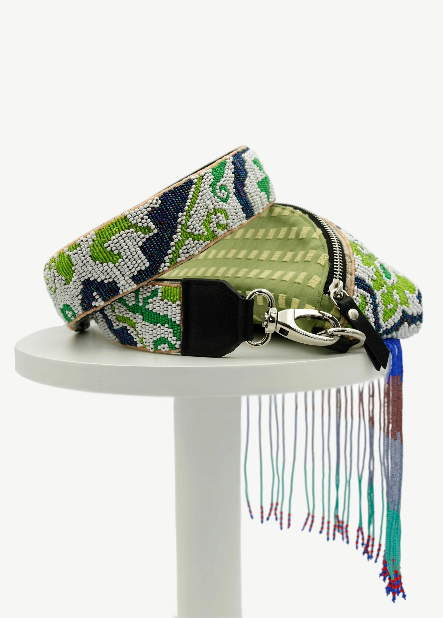 KABE SHOP INC Lunverde handmade bag with green fabric, intricate beaded strap, and long multi-colored fringe detail.