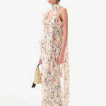 Model wearing KABE SHOP INC Monica dress with floral print, ruffle details, and a detachable scarf on white background