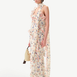 Model wearing KABE SHOP INC Monica dress with floral print, ruffle details, and a detachable scarf on white background
