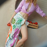 KABE SHOP INC Morning Dew cotton pareo with pink and terracotta botanical print worn by a model in a striped shirt