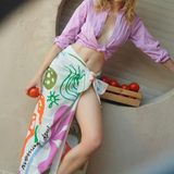 KABE SHOP INC Morning Dew cotton pareo with pink and terracotta botanical print worn by a model in a striped shirt