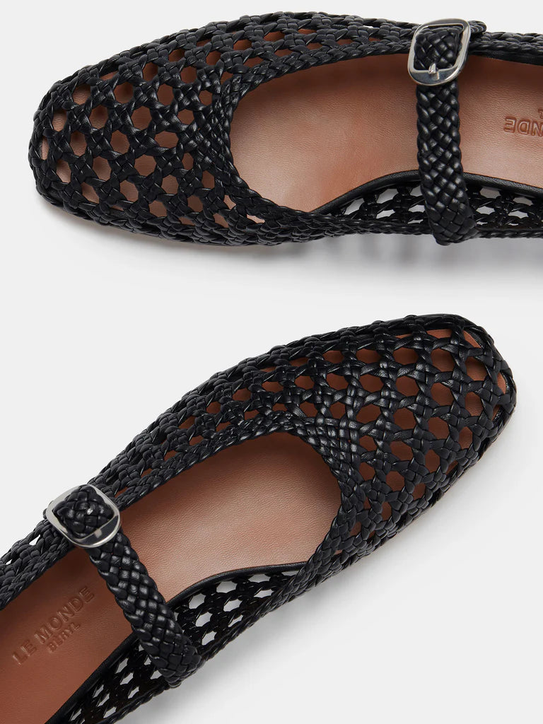Two black Mary Jane Woven Leather Shoes with a handwoven goatskin upper and classic buckle strap, displayed from above on a white background. The intricate open weave showcases the tan insoles inside the shoes.