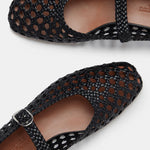 Two black Mary Jane Woven Leather Shoes with a handwoven goatskin upper and classic buckle strap, displayed from above on a white background. The intricate open weave showcases the tan insoles inside the shoes.