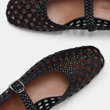 Two black Mary Jane Woven Leather Shoes with a handwoven goatskin upper and classic buckle strap, displayed from above on a white background. The intricate open weave showcases the tan insoles inside the shoes.