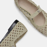 Two Mary Jane Woven Leather Shoes in beige handwoven goatskin are displayed on a white background—one shown from above and the other from the side—showcasing their intricate woven design and delicate buckle fastening on the slim strap.