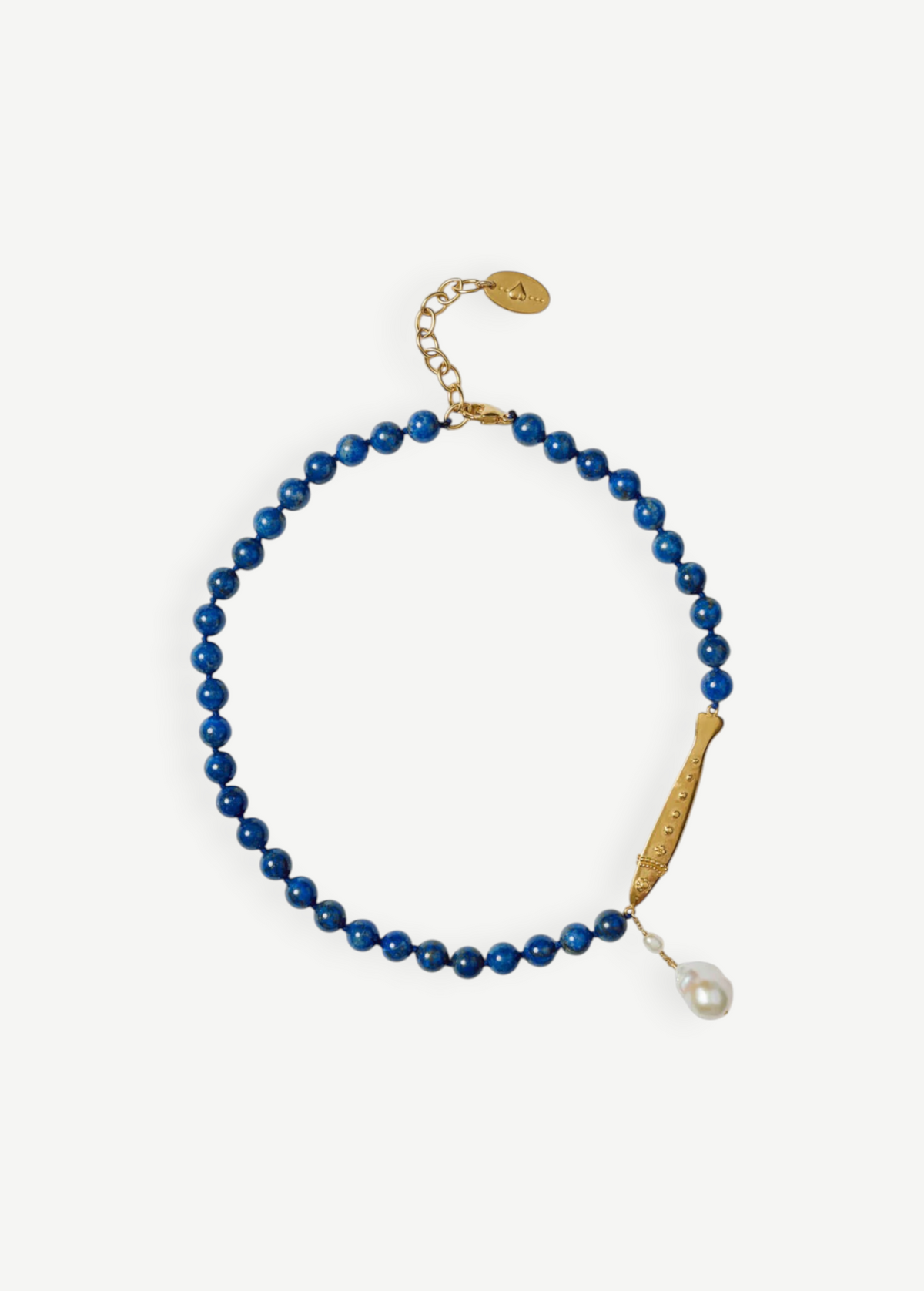 KABE SHOP INC Ospina necklace featuring blue lapis beads, a gold fish pendant, and a freshwater pearl charm.