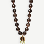 KABE SHOP INC Lark Drip necklace with faceted smoky quartz beads, gold claw pendant, and small peridot drop accents.