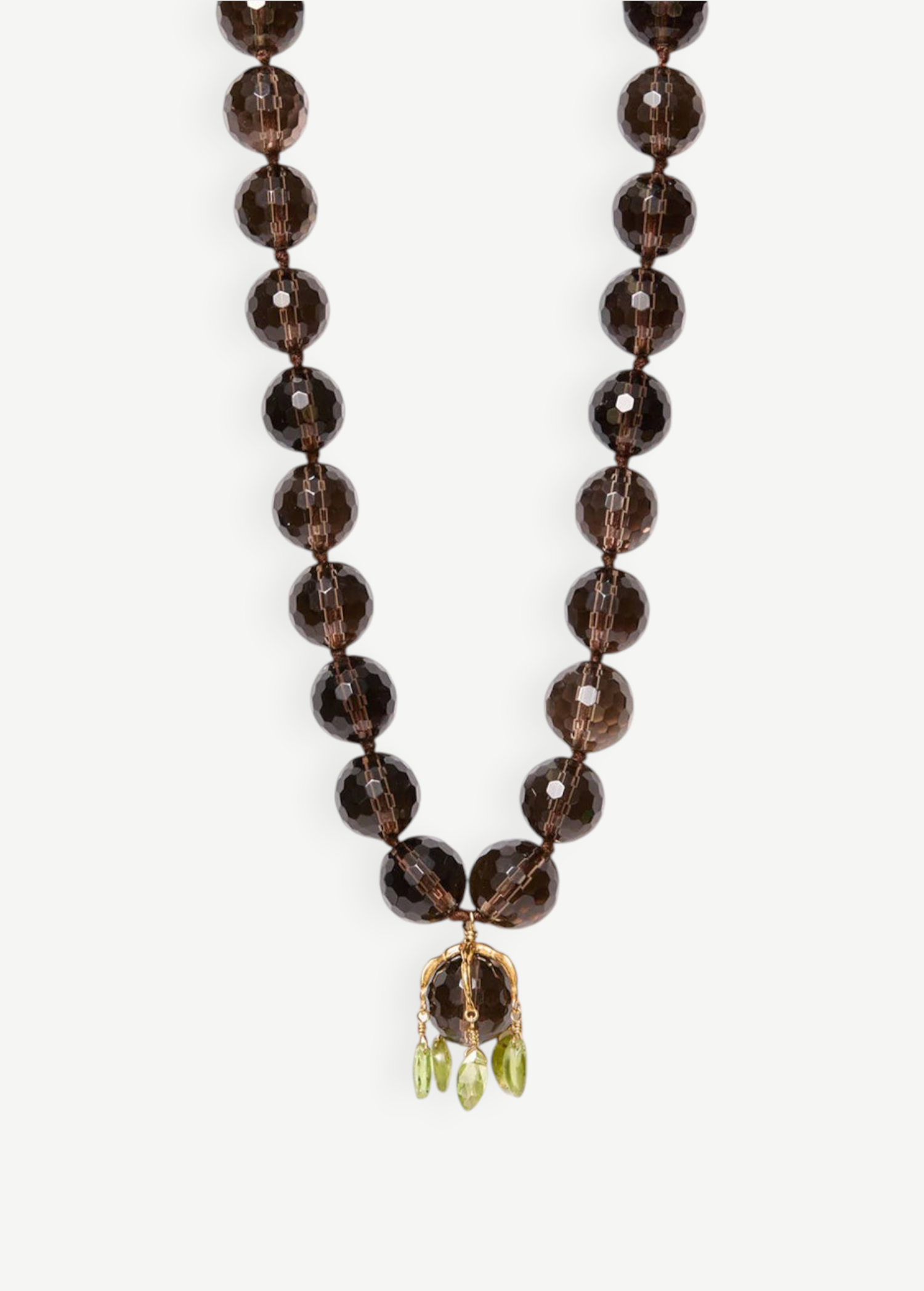 KABE SHOP INC Lark Drip necklace with faceted smoky quartz beads, gold claw pendant, and small peridot drop accents.
