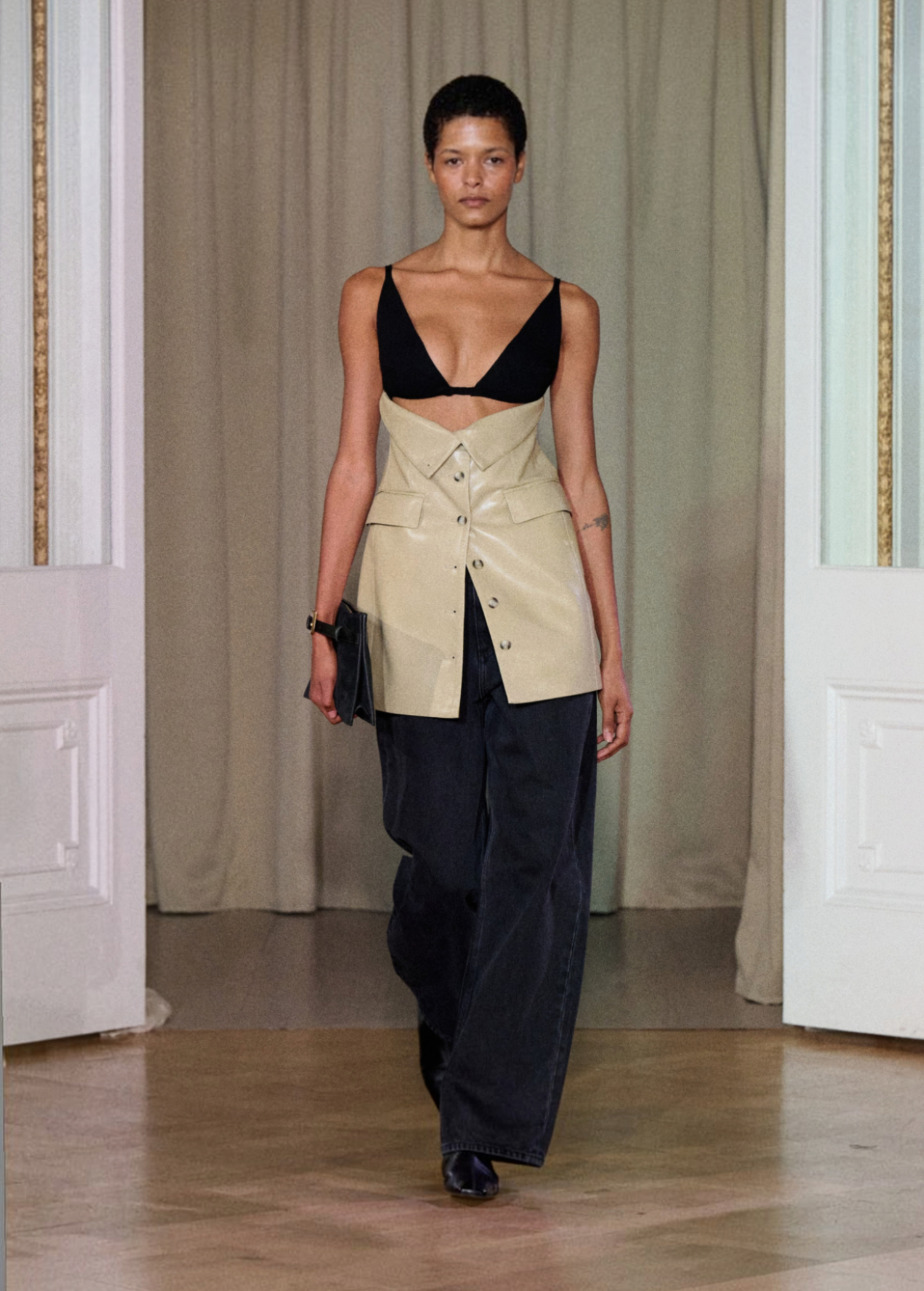 A model walks indoors wearing the Zyana Dress. The background features cream curtains and white paneled walls.