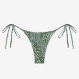 Praia Bottom: A green triangle bikini bottom with a white dotted leaf print, adjustable side ties at the hips, made from recycled nylon and shown against a plain white background.