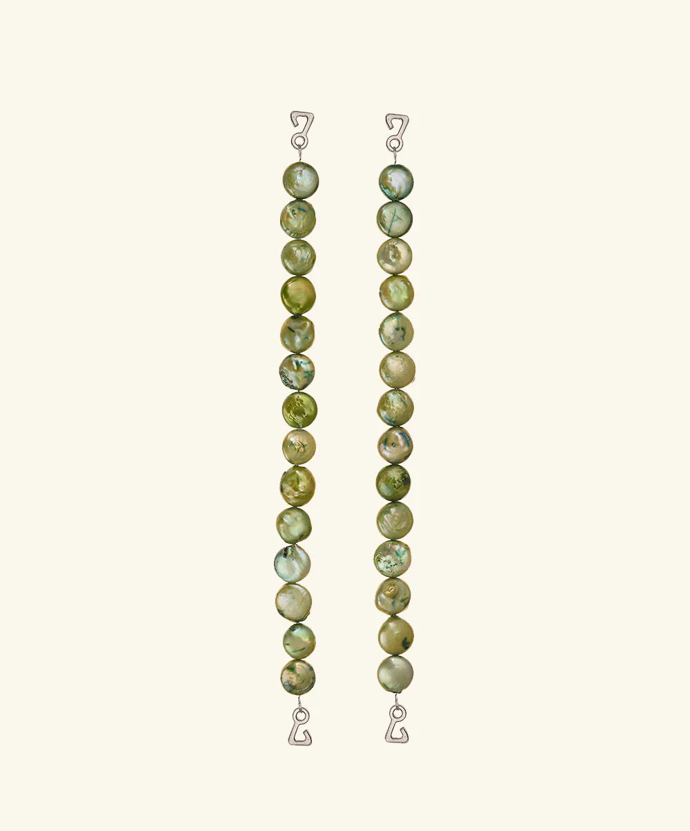 Two vertical strands of round, green marbled beads with wire hooks at each end serve as elegant jewelry straps for the Dolores Top Classic Swimwear, set against a plain light background.