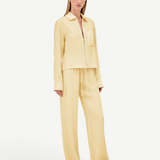 A model wears a pale yellow zip-up shirt and matching Damian Pant wide-leg trousers with an elastic drawstring waist for a polished style.