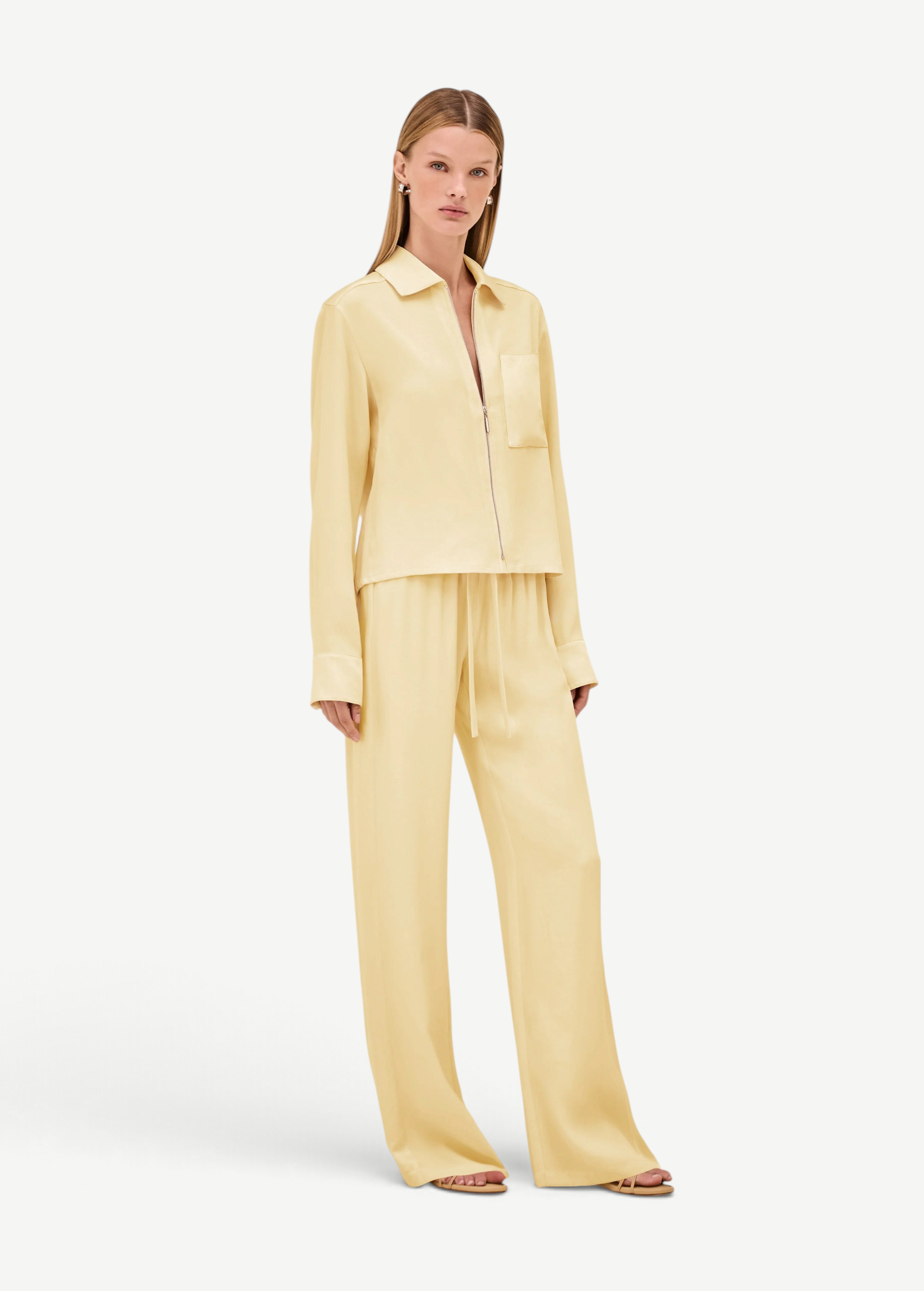 A model wears a pale yellow zip-up shirt and matching Damian Pant wide-leg trousers with an elastic drawstring waist for a polished style.