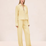 A model wears a pale yellow zip-up shirt and matching Damian Pant wide-leg trousers with an elastic drawstring waist for a polished style.
