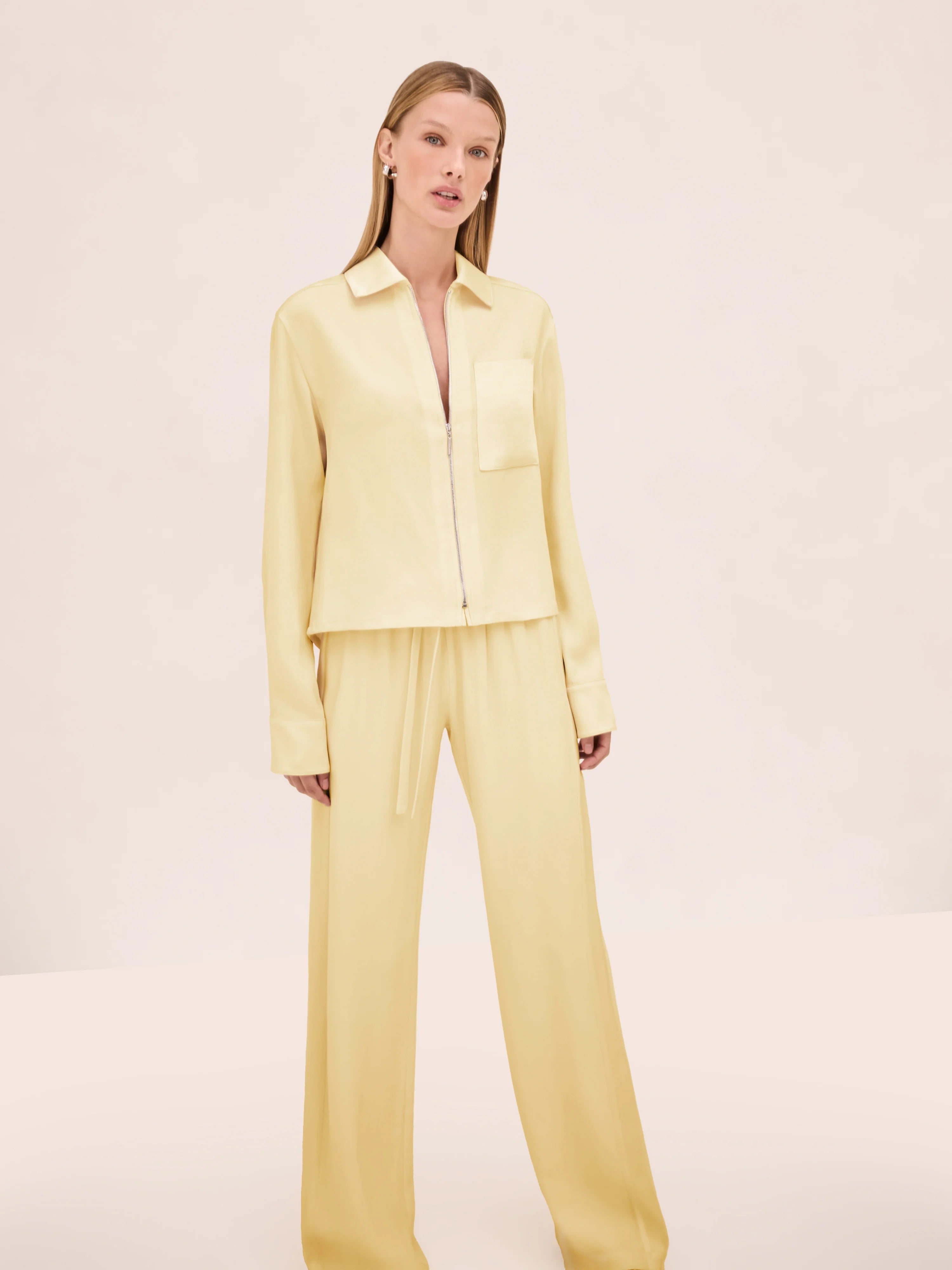 A model wears a light yellow zip-up shirt with matching Damian Pant wide-leg trousers featuring a drawstring waist for a polished style.
