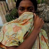 KABE SHOP INC long wrap dress in green floral sari fabric with bohemian embroidery, worn by a model near cacti.