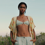 Model wearing a KABE SHOP INC bohemian long wrap robe with floral embroidery over a light green bikini top and pants