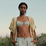 Model wearing a KABE SHOP INC bohemian long wrap robe with floral embroidery over a light green bikini top and pants