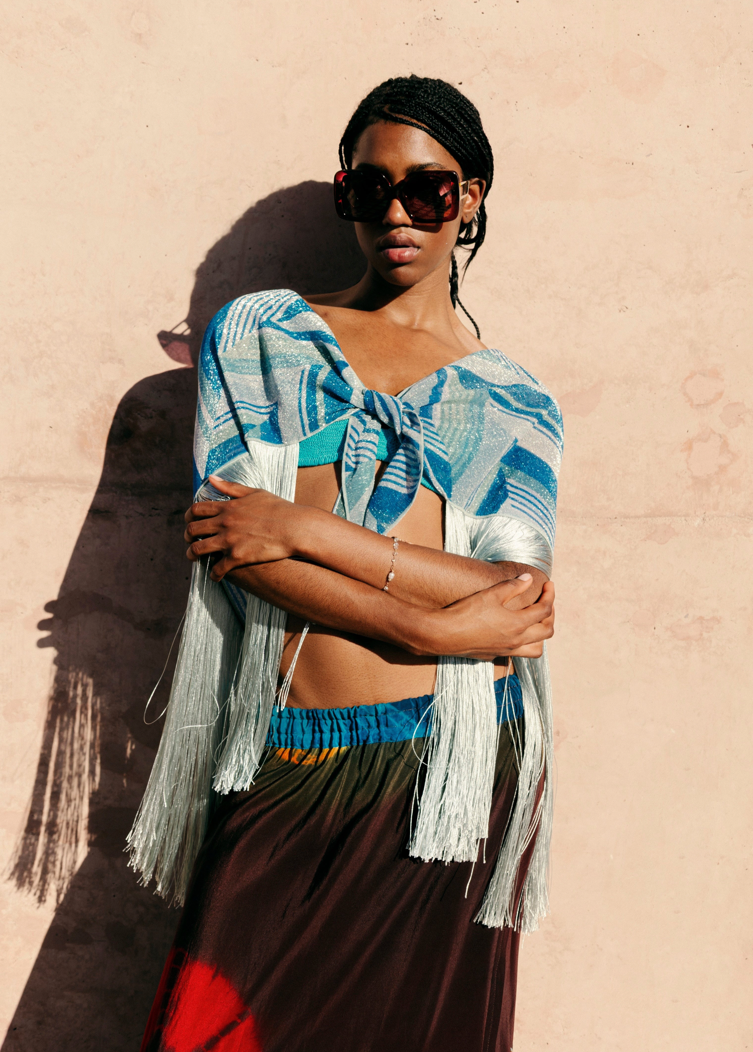 Model wearing KABE SHOP INC Jupe Chantal skirt with a blue patterned wrap top featuring long fringe details