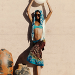Model wearing KABE SHOP INC Jupe Chantal skirt with bohemian sari-inspired patterns against a textured wall
