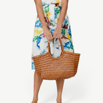 KABE SHOP INC Nantucket Basket Big tote bag in brown handwoven Buffalo Calf leather held by a woman in a floral dress