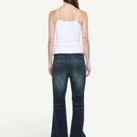 Back view of a woman wearing a KABE SHOP INC white ribbed cami top paired with dark wash flared denim jeans