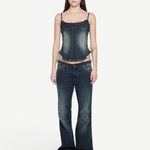 A woman wears a Denim Corset Top with ruffle accents paired with wide-leg denim jeans, creating a sculptural silhouette.