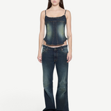 A woman wears a Denim Corset Top with ruffle accents paired with wide-leg denim jeans, creating a sculptural silhouette.