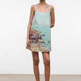 The Brio Dress features a square neckline and a printed coastal scene of a crowded beach and ocean, making it a warm-weather essential.