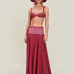 A person wearing a maroon bikini top and matching Rylie Skirt featuring a white floral pattern, styled with a wide-brimmed bucket hat in the same fabric.